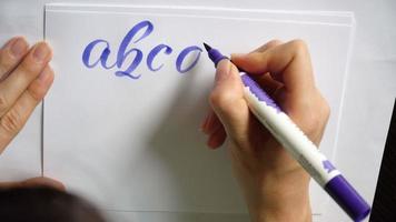 Woman hand writes a calligraphic alphabet  video