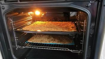 View of a cake inside an oven with the door open