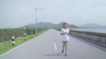 Aziatische vrouw rennen en joggen op straat. video