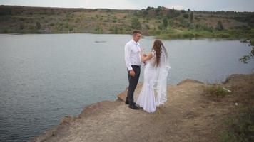 Bride And Groom Embrace At The Lake