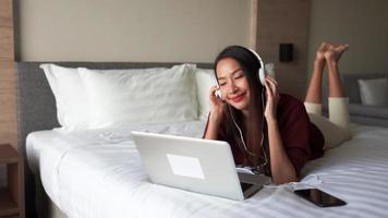 mujer joven, escuchar música, en cama video