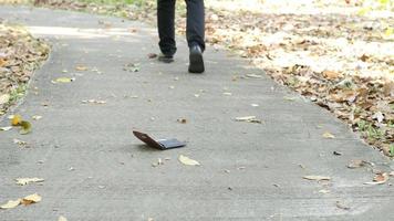 Räuber stehlen fallende Brieftasche vom gehenden Mann
