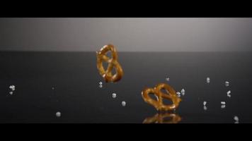 Pretzels and salt falling onto a reflective surface - PRETZELS 022 video