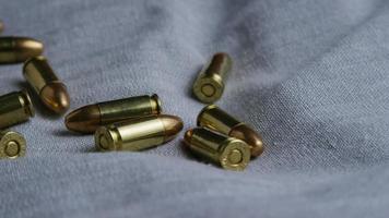 Cinematic rotating shot of bullets on a fabric surface - BULLETS 084 video