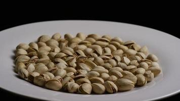 Cinematic, rotating shot of pistachios on a white surface - PISTACHIOS 020