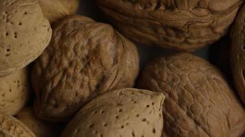 Cinematic, rotating shot of a variety of nuts on a white surface - NUTS MIXED 009 video