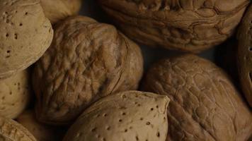 Cinematic, rotating shot of a variety of nuts on a white surface - NUTS MIXED 009 video