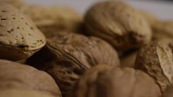 Cinematic, rotating shot of a variety of nuts on a white surface - NUTS MIXED 033 video