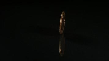 goldene Münze, die sich in Ultra-Zeitlupe (1.500 fps) auf einer reflektierenden Oberfläche dreht - Geldmünzen-Phantom 001 video