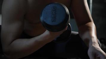 Young man hand holding dumbbell up exercises at gym fitness video