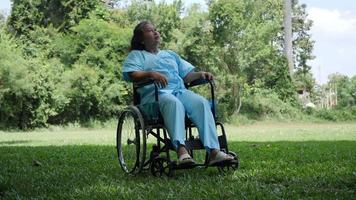einsame behinderte ältere Frau, die allein im Park auf Rollstuhl sitzt video