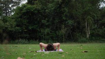 hermosa mujer está haciendo yoga en el parque