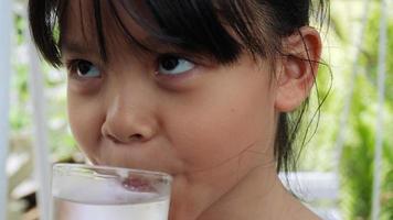 petite fille buvant de l'eau fraîche après avoir joué video