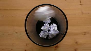 Throw crumpled paper into trash with black background