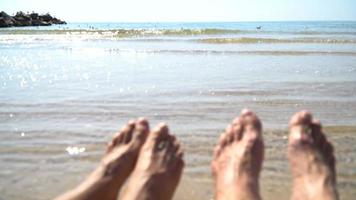 Man and woman legs against the sea on the summer beach, time to travel. Empty place for a text video