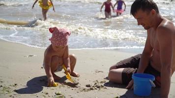 barn som leker med sand på stranden video