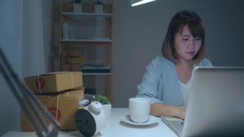 donna asiatica che viene su un computer portatile a casa video