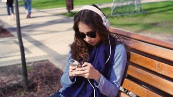 ung kvinna som lyssnar på musik i parken