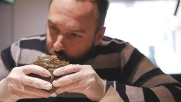 hombre barbudo comiendo una hamburguesa video