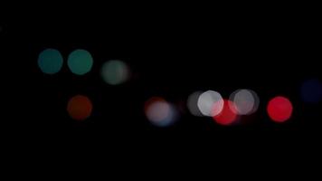 Small bokeh lights of vehicles circulating in both directios and big lights with transparency in 4K video