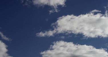 Laps de temps de nuages blancs de différentes tailles s'éloignant et disparaissant sur un ciel bleu en 4k video