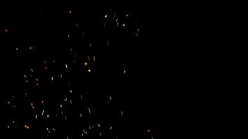 brasas de fuego caliente que brillan sobre un fondo oscuro en 4k video
