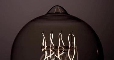 Extrem nahe an der Vintage-Glühbirne mit frühlingswarmem Filament, das in 4k schnell blinkt video