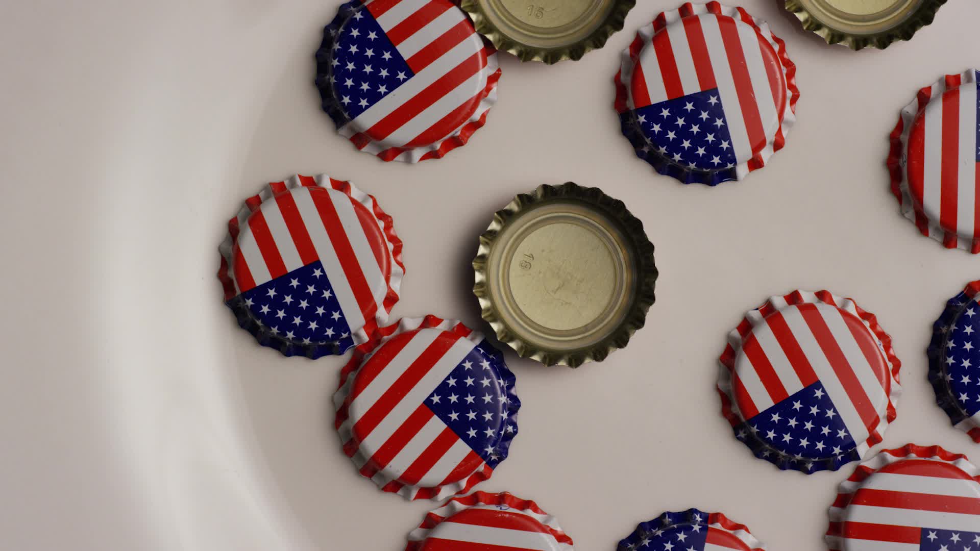 Rotating shot of bottle caps with the American flag printed on them