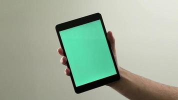 Tablet mini en la mano - clave de croma / pantalla verde lista video