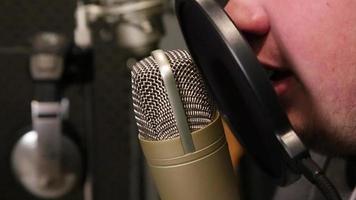 rack focus shot de um cantor cantando em uma cabine de som video