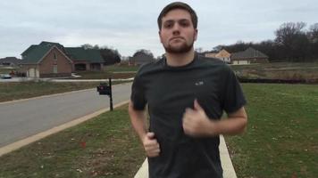 macho corriendo en una acera a través de un barrio video