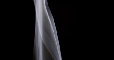 delicadas linhas finas criando belas colunas de fumaça branca sobre fundo escuro em 4k video