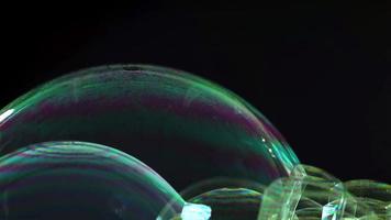 close-up de bolhas de sabão verdes roxas e azuis