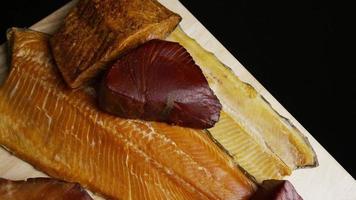 Rotating shot of a variety of delicious, premium smoked meats on a wooden cutting board - FOOD 058 video