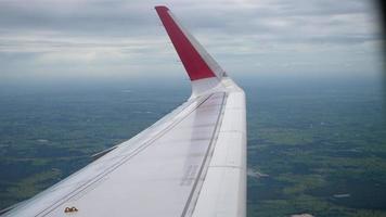 Wing of an airplane flying above the clouds from window plane view video