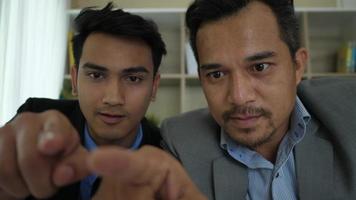 Two businessmen looking and analyzing business chart on monitor video