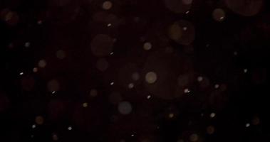 helle Partikel mit Bokeh-Effekt fallen wie Schnee auf dunklem Hintergrund in 4k