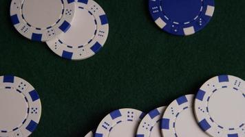 Rotating shot of poker cards and poker chips on a green felt surface - POKER 032