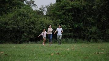 Zeitlupe der Eltern mit laufender Tochter genießen im Park video