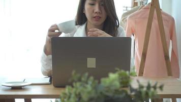 bela jovem sorridente chegando no laptop enquanto desfruta de um café quente. video