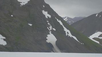 un helicóptero volando alrededor de montañas nevadas en alaska 4k video