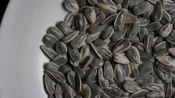 Cinematic, rotating shot of sunflower seeds on a white surface - SUNFLOWER SEEDS 003 video