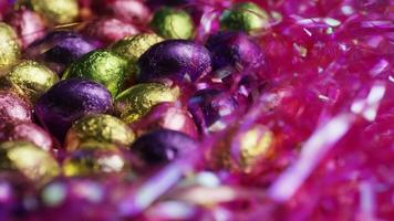 Tournage de bonbons de Pâques colorés sur un lit d'herbe de Pâques - Pâques 220 video