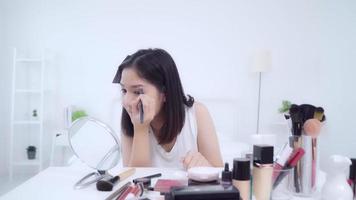 glücklich schöne junge asiatische Frau verwenden Kosmetik Bewertung Make-up Tutorial Übertragung Live-Video an Social Netcom. video