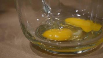 Close-up of an egg yolk breaking into bowl | Free Stock Footage video
