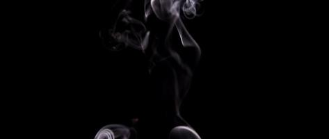 Hypnotic white smoke drawing soft swirls blurred in foreground in 4K video