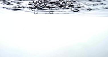Monochromatic scene of six groups of drops creating little bubbles in water container in 4K video