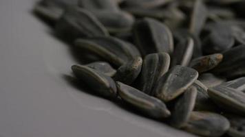 Cinematic, rotating shot of sunflower seeds on a white surface - SUNFLOWER SEEDS 022 video