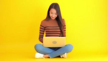 kvinnan använder bärbara datorn på en gul bakgrund video