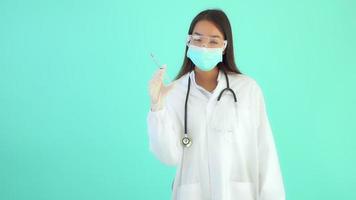 schöne asiatische Ärztin auf blauem isoliertem Hintergrund video